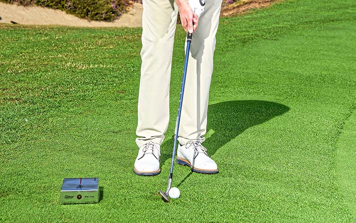 Golftraining Kurzspiel: Platzieren Sie einen niedrigen Gegenstand eine Fußlänge hinter dem Ball